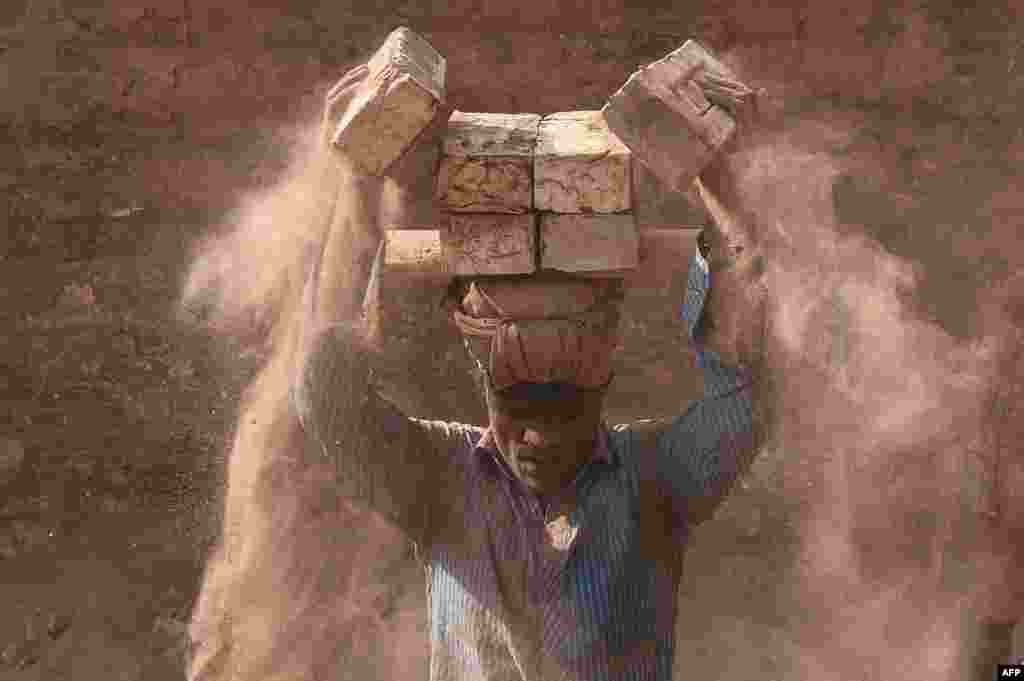 A man carries bricks in a brickfield in Saver on the outskirts of Dhaka, Bangladesh.