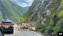 中国西南部四川省甘孜州泸定县当地时间星期一（2022年9月5日）下午发生6.8级地震。新华社发布的照片显示地震造成山体滑坡，巨石滚落，车辆通行受阻。-美联社/新华社照。