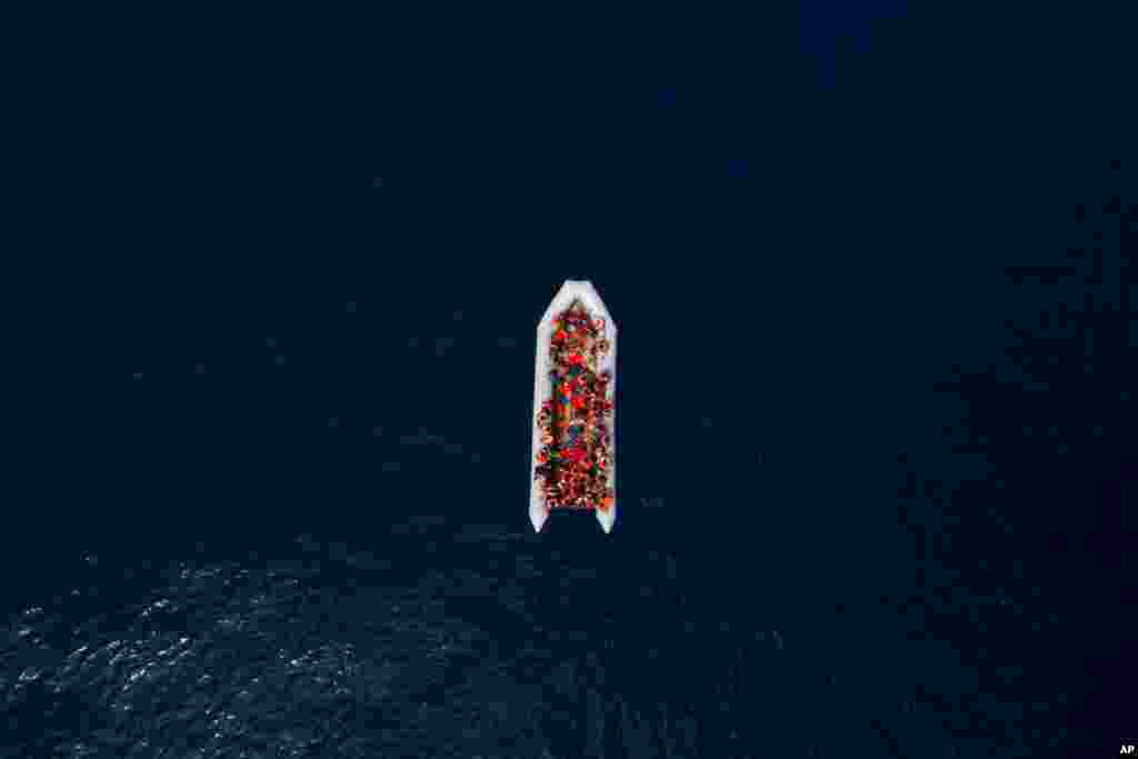Refugees and migrants wait to be rescued by members of the Spanish NGO Proactiva Open Arms, after leaving Libya trying to reach European soil aboard an overcrowded rubber boat, north of Libyan coast.