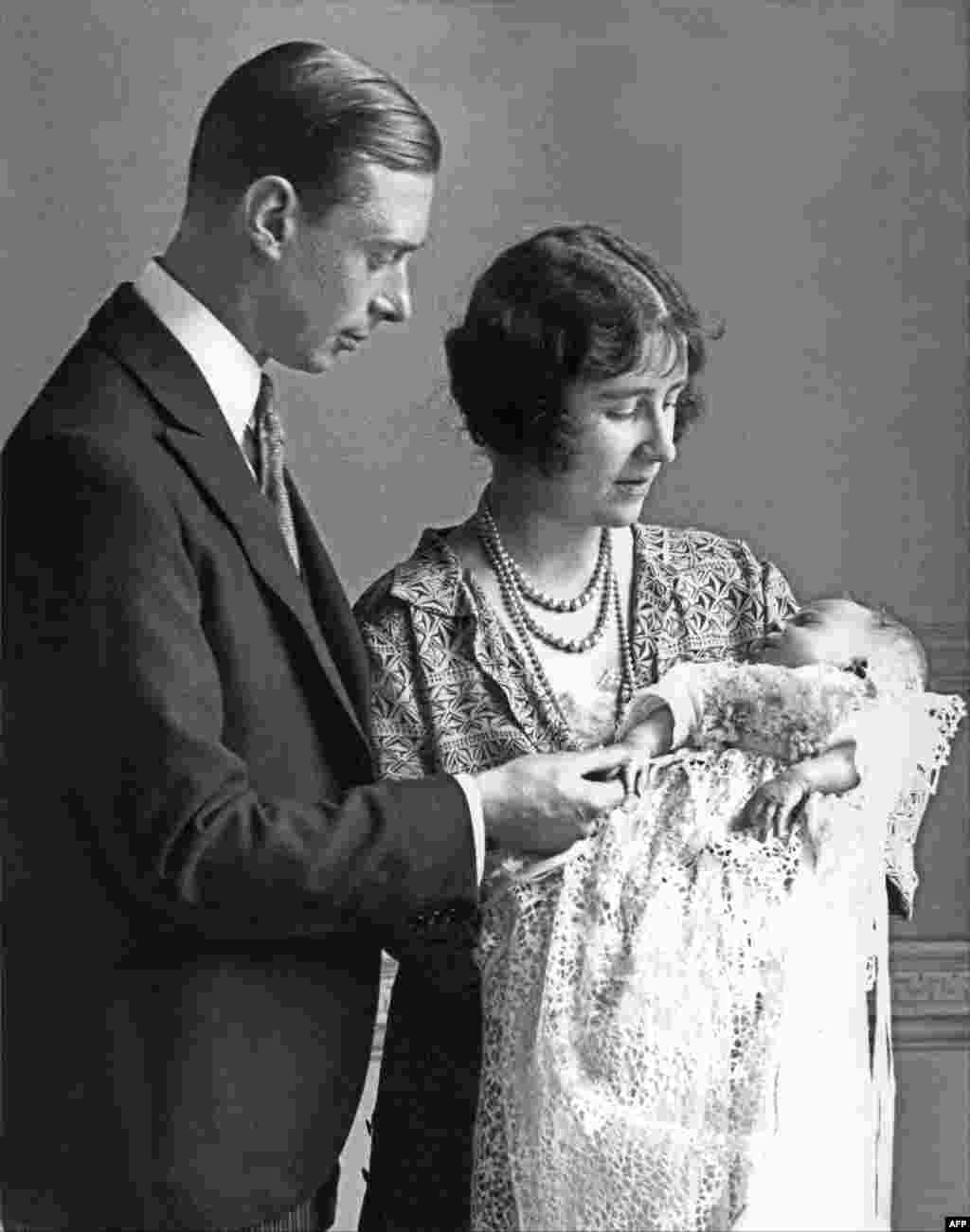 Phu nhân Elizabeth Angela Marguerite Bowes-Lyon, con gái của Bá tước Strathmore thứ 14, Nữ công tước xứ York (phải) bế đứa con đầu lòng của bà, Công chúa Elizabeth, vào năm 1926, bên cạnh chồng bà, Công tước xứ York. Em bé sinh ngày 21 tháng 4. 
