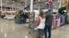 资料照片：2024年2月25日，在科罗拉多州谢里登的开市客 (Costco )仓库中，购物者们走过展示的商品。(美联社照片)
