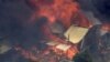 FILE - This image made from video shows home engulfed in flames outside Perth, Australia, Dec. 21, 2023.