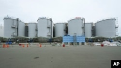 2023年7月14日，在日本二叶町的福岛第一核电站，一条黑色管道沿着装有处理过的放射性废水的水箱延伸。