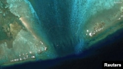 卫星图像显示在南中国海有主权争议的斯卡伯勒浅滩（中国称黄岩岛）潟湖入口处被安放了一道新的浮动屏障。（2024年2月24日）