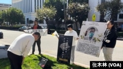 2月10日，活动参与者在洛杉矶中领馆门口向李文亮遗像鞠躬悼念。（2024年2月10日，张木林洛杉矶拍摄）