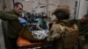 FILE - Ukrainian military medics treat a wounded Ukrainian serviceman at a stabilisation point near Bakhmut, Donetsk region, on Feb. 9, 2024,