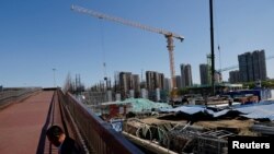 一名男子坐在北京一处建筑工地旁。（2023年4月18日）