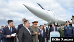 资料图：朝鲜领导人金正恩在时任俄罗斯国防部长绍伊古陪同下参观符拉迪沃斯托克军事基地的核轰炸机。（2023年9月16日）