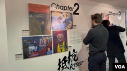 《移英港人—希望与不屈的进行曲》艺术展在利兹市举行，图为英国本地人驻足抵抗(Resist)前，阅读港人的抗争经历。（美国之音 李伯安）