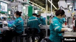 2022年2月17日，中国北京施耐德电气工厂的员工在生产线上工作。