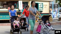 北京一家商场外的妇女和孩子（资料照：2014年10约18日）