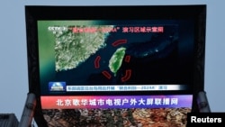 资料照片：北京街头巨幅电视屏幕播放中国军队东部战区绕台军演的新闻。(2024年5月23日)