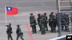 资料照片：一名士兵在台湾桃园举行的一年一度的汉光军事演习举着中华民国国旗。(2023年7月26日)