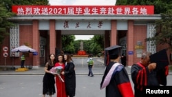 资料照：上海复旦大学学生在校门拍摄毕业照。（2021年6月25日）