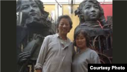 中国艺术家严正学(左)在其雕塑作品前拍照（照片来自高瑜推特）