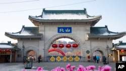 资料照片：2020年1月23日，游客们走过中国吉林省吉林市北山公园的大门。(美联社照片)