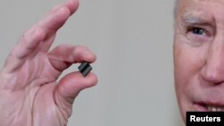 拜登总统在白宫签署有关解决全球半导体芯片短缺的行政令期间手拿芯片发表讲话。（2021年2月24日）