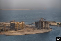 A ferry sails by a construction site in Al Khan, near Dubai, United Arab Emirates, Aug. 13, 2024.