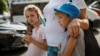 10-річна Ангеліна та 9-річний Олександр возз'єднані зі своєю матір'ю Світланою після повернення з окупованої території України, 6 вересня 2023. За даними Києва, до Росії було депортовано понад 19 500 дітей. Повернути вдалось лише близько 400 дітей. REUTERS/Gleb Garanich