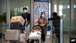 资料照片：2023年4月26日，乘坐国际航班抵达北京机场的旅客走出抵达区。（美联社照片）
