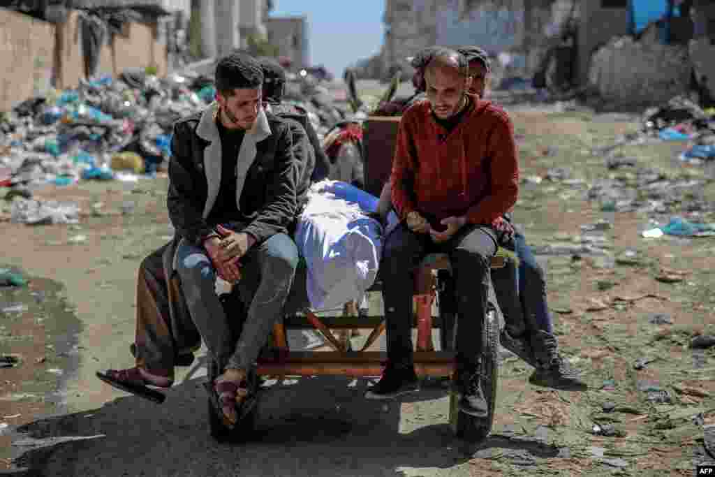 The body of a Palestinian killed in an early morning incident when residents rushed toward aid trucks in Gaza City. At least 104 Palestinians were killed as Israeli troops opened fire on people trying to get food from humanitarian aid trucks.