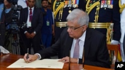 2022年7月21日，斯里兰卡新当选总统拉尼尔·维克勒马辛哈（Ranil Wickremesinghe）在科伦坡宣誓就职后签字。照片由斯里兰卡总统办公室发布，美联社提供。