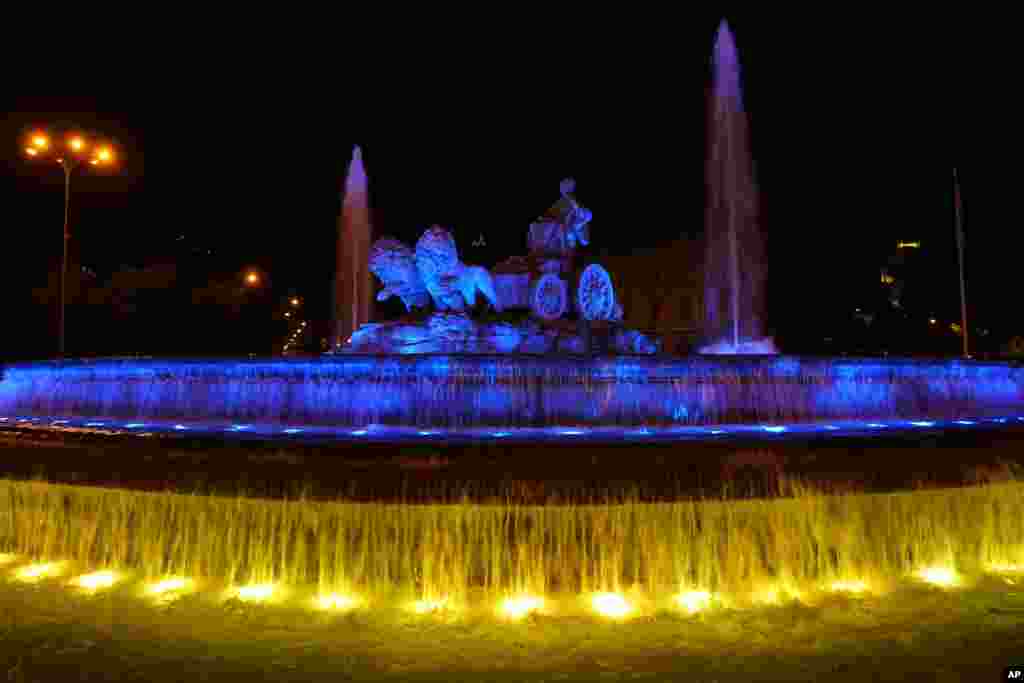 The Cibeles statue and fountain is illuminated with the colors of the Ukrainian flag in Madrid, Spain, Aug. 24, 2022.