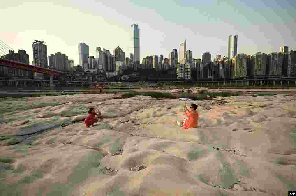 People are seen at the dried-up riverbed of the Jialing river, a tributary of the Yangtze River in China's southwestern city of Chongqing.