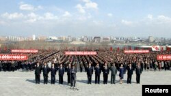朝鲜人民2013年4月10日在平壤万寿山的已故领导人金日成和金正日的雕像前参与宣誓。 