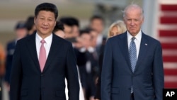 资料照片：2015年9月24日时任副总统拜登与到访的中国国家主席习近平在安德鲁斯基地 