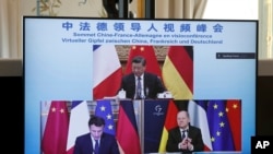 屏幕显示中国领导人习近平、法国总统马克龙和德国总理朔尔茨在视频会议上商讨乌克兰危机问题。（2022年3月8日）