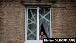 Жінка у вікні будівлі в місті Часів Яр біля Бахмута в Донецькій області, де відбуваються найзапекліші бої на цьому етапі російської війни проти України. 5 січня 2023 р.