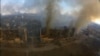 
2022年3月14日，乌克兰马里乌波尔发生爆炸，鸟瞰图显示受损住宅楼冒出浓烟。这张静止图像是从社交媒体获取的无人机镜头中拍摄的。 