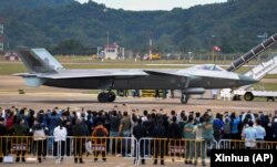 在第14届珠海航空航天展览会上，中国制造的歼-20重型隐身战斗机停在跑道上供参观者拍照。（2022年11月8日）