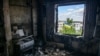 Український національний прапор у вікні зруйнованої під час вторгнення Росії в Україну квартири в місті Бородянка Київської області, Україна, 13 травня 2022 року. REUTERS/Владислав Мусієнко