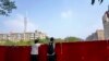 中国广东广州被封的海珠区居民从围栏里向往张望。（2022年11月11日）