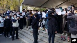 北京清华大学的学生手举白纸抗议严厉的防疫政策，悼念日前在新疆乌鲁木齐市死于火灾的至少10名遇难者。 （2022年11月27日）