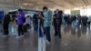 旅客在北京首都国际机场国际航班值机柜台办理登机手续后使用智能手机填写健康申明。（2022年12月29日，资料照片）