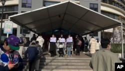 北京清华大学的学生手举白纸抗议严厉的防疫政策，悼念日前在新疆乌鲁木齐市死于火灾的至少10名遇难者 (022年11月27日)