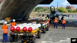 台湾军队士兵站在F16V战机前，准备进行装载美制AGM-84鱼叉反舰导弹及AIM-120和AIM-9空空导弹的训练。（2022年9月16日）