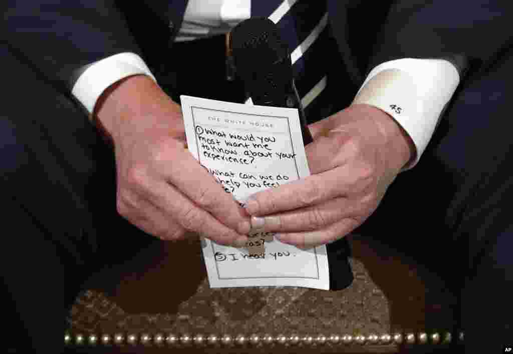 U.S. President Donald Trump holds notes during a listening session with high school students and teachers in the State Dining Room of the White House in Washington, Feb. 21, 2018. Trump heard the stories of students and parents affected by school shootings, following last week's deadly shooting in Florida.