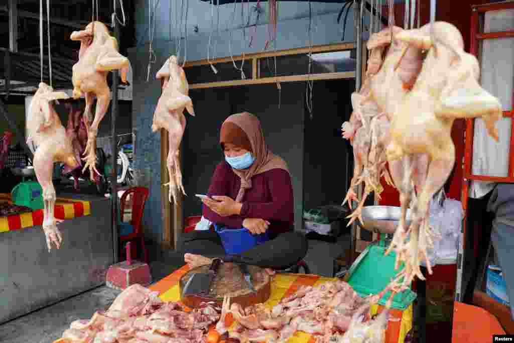 A vendor wearing a protective face mask sells food at a fresh market during a 14-day citywide lockdown implemented amid a rising number of coronavirus cases, in Phnom Penh, Cambodia.