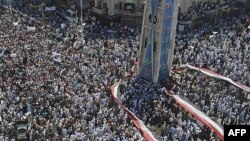 Ðám đông biểu tình chống Tổng thống Bashar al-Assad giương ra một lá cờ Syria lớn tại trung tâm thành phố Hama, Syria, ngày 29 tháng 7, 2011