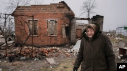 Жителька села Андріївка поруч зі зруйнованим будинком після звільнення села від окупації.  AP Photo. Автор Vadim Ghirda