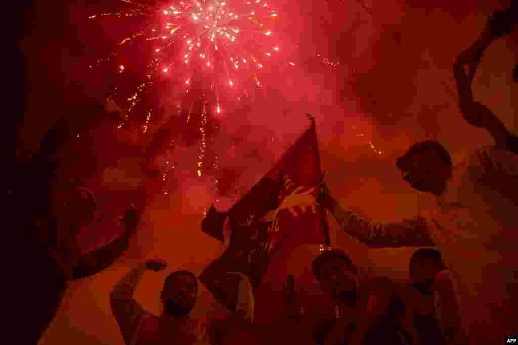 Pakistan Peoples' Party (PPP) supporters celebrate on the street after a Supreme Court ruling in Karachi.