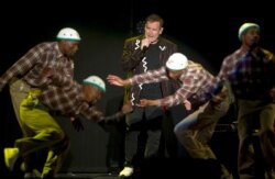 In this photo taken Saturday, July 2017, South African musician Johnny Clegg, middle, and the dancers perform during "The Final Journey" concert at the Grand Arena in Cape Town, South Africa.