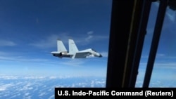 据美国军方称，一架中国海军歼-11战斗机在南中国海上空的国际空域靠近美国空军RC-135飞机飞行，视频拍摄于2022年12月21日。