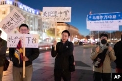 在美国首都华盛顿白宫附近举行抗议的人群手举要求共产党下台的标语。（2022年12月4日）