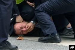资料照：上海警察把一名抗议中国严厉防疫政策的青年压倒在地。（2022年11月27日）