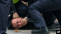 上海警察把一名抗议中国严厉防疫政策的青年压倒在地。（2022年11月27日）